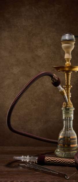 Egyptian hookah (shisha) on dark brown table on dark background.